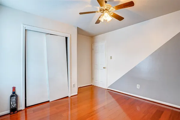 a view of a room with a ceiling fan and wooden floor