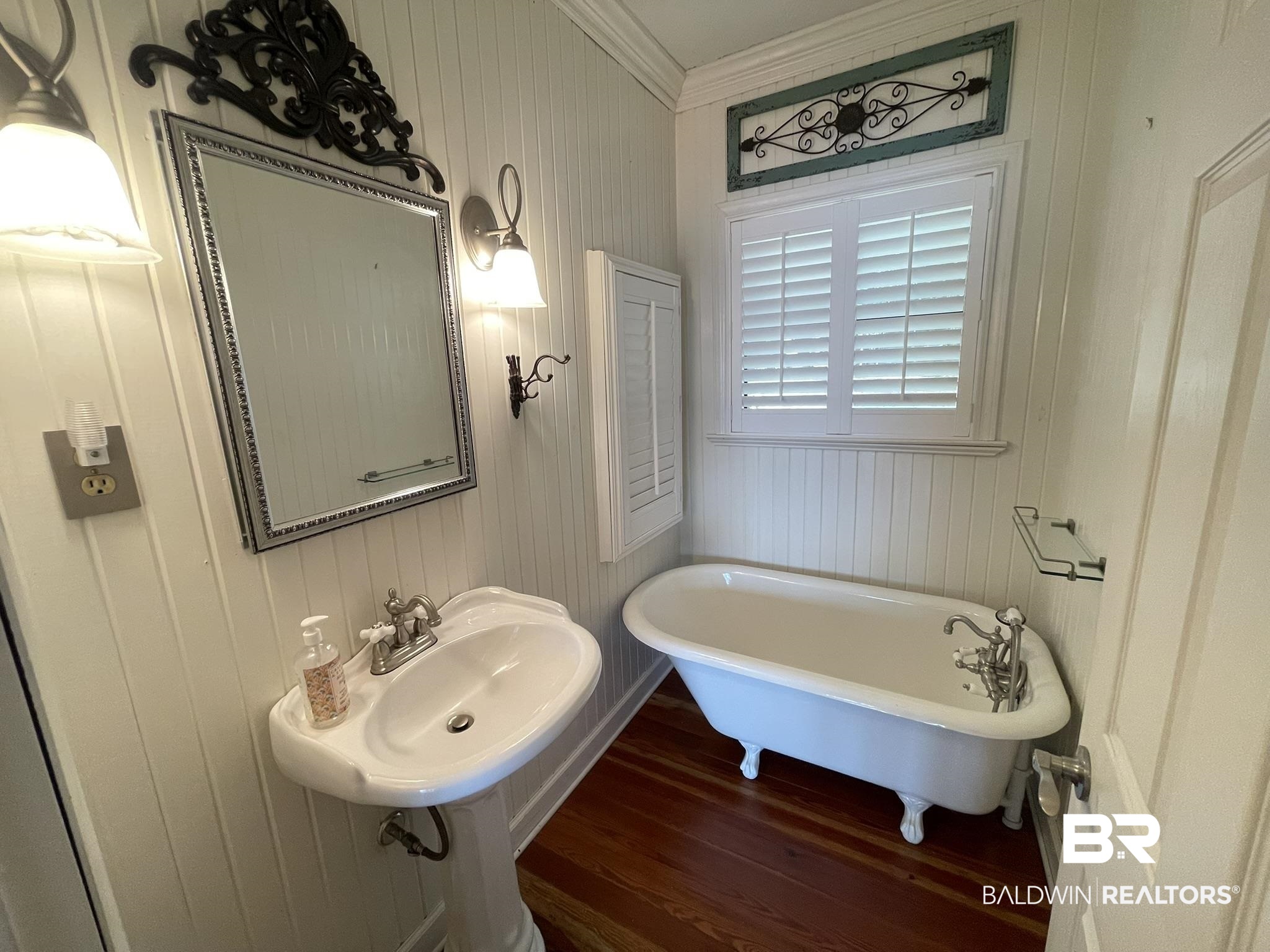 6621 Purvis Road Daphne, AL 36527 - Photo 22 of 59 Bathroom with crown molding, a freestanding tub, dark wood-style flooring, and wood walls
