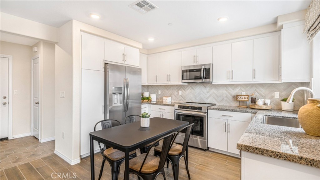 7353 Olive Grv Street Riverside, CA 92507 - Photo 1 of 1 a kitchen with granite countertop stainless steel appliances a stove refrigerator sink and cabinets