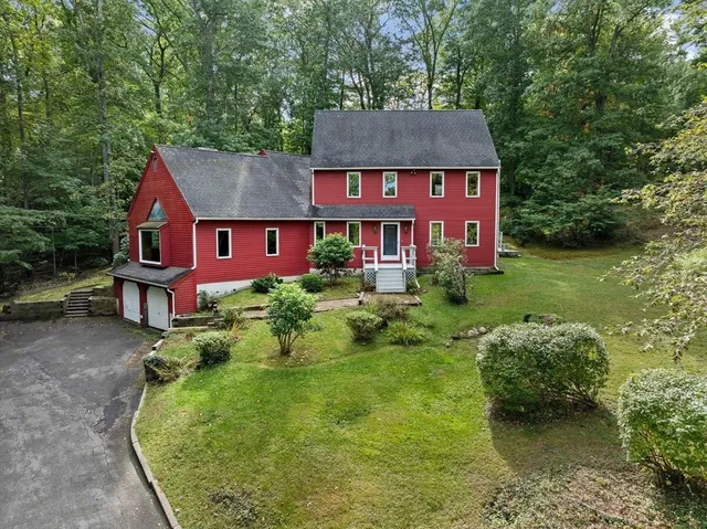 an aerial view of a house with swimming pool and red chairs