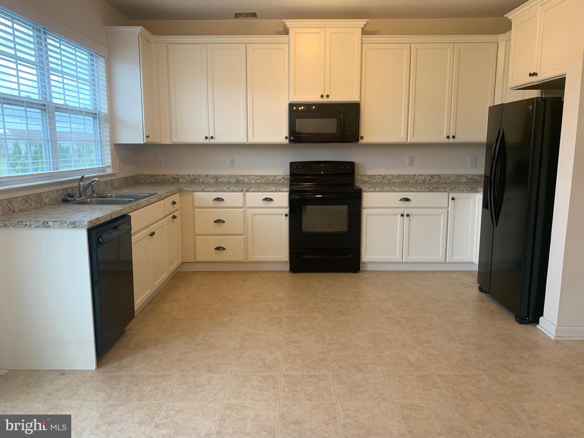 2156 Audubon Trail Middletown, DE 19709 - Photo 3 of 8 a kitchen with granite countertop a refrigerator stove and sink