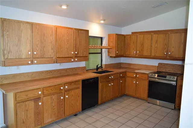 a kitchen with stainless steel appliances granite countertop a sink dishwasher stove and cabinets
