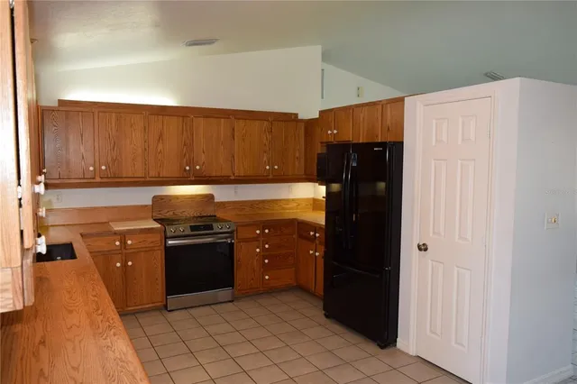 a kitchen with stainless steel appliances granite countertop a refrigerator and a stove