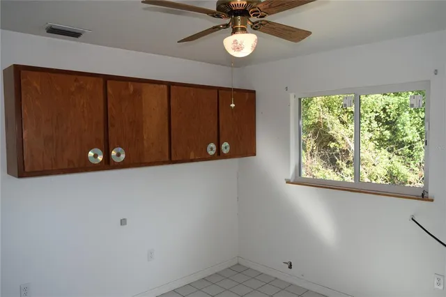 an empty room with windows and fan
