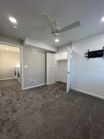 an empty room with an entryway and fan