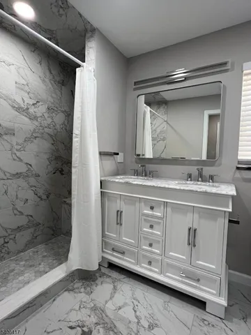 a bathroom with a double vanity sink mirror and shower