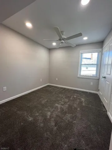 en empty room with windows and ceiling fan
