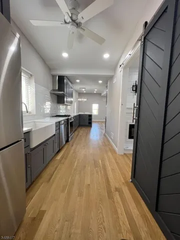 a large kitchen with stainless steel appliances a large counter top a sink a stove a refrigerator and cabinets