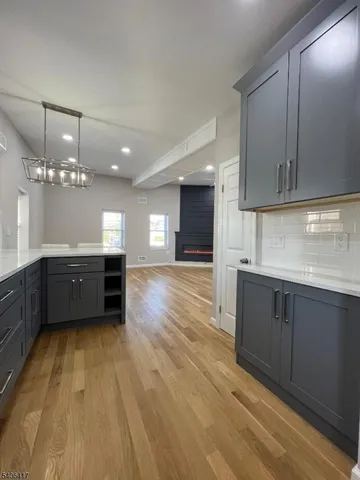 a kitchen with stainless steel appliances a sink cabinets and wooden floor