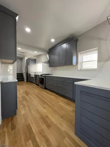 a large kitchen with stainless steel appliances granite countertop a sink and a stove