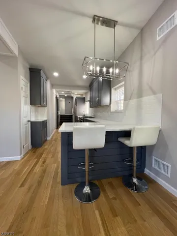 a room with kitchen island stainless steel appliances living room view and furniture