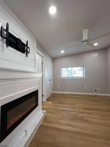 a view of an empty room with a fireplace and a window
