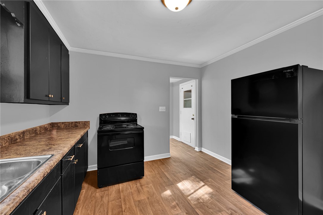403 Lewis Street Anderson, SC 29624 - Photo 11 of 35 Warm wood flooring grounds this functional kitchen layout complete with matching dark cabinetry.