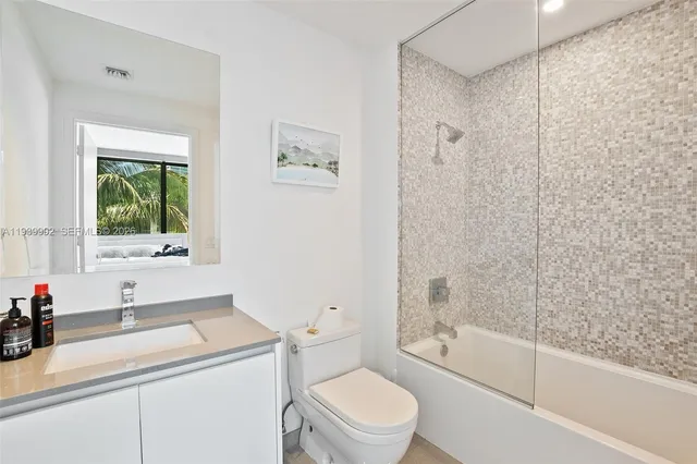 a bathroom with a granite countertop sink mirror vanity and toilet