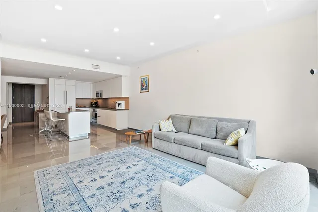 a living room with furniture and view of kitchen