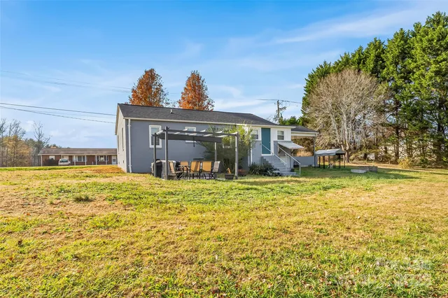 a view of a house with a yard and sitting area