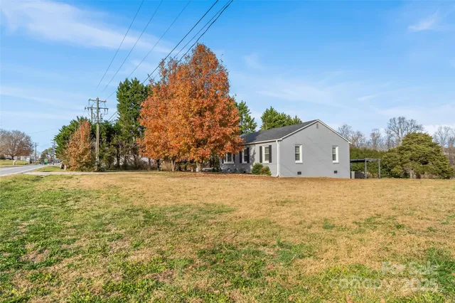 a front view of house with yard and trees in the background