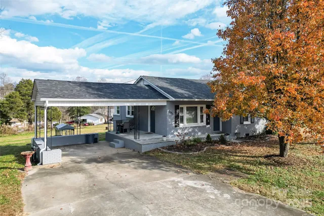 a view of a house with a yard and sitting area