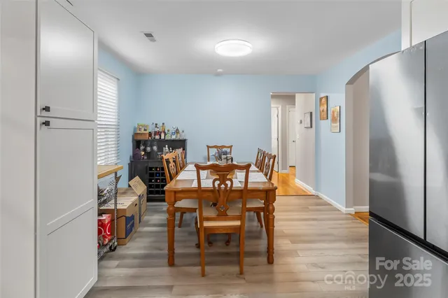 a view of a dining room with furniture a rug and wooden floor