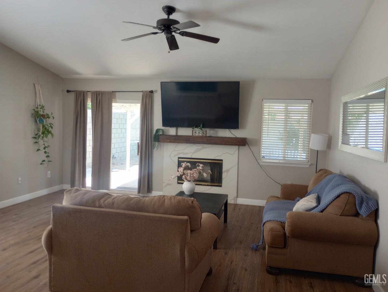 Undisclosed Address Bakersfield, CA 93313 - Photo 5 of 18 a living room with furniture a flat screen tv and a fireplace
