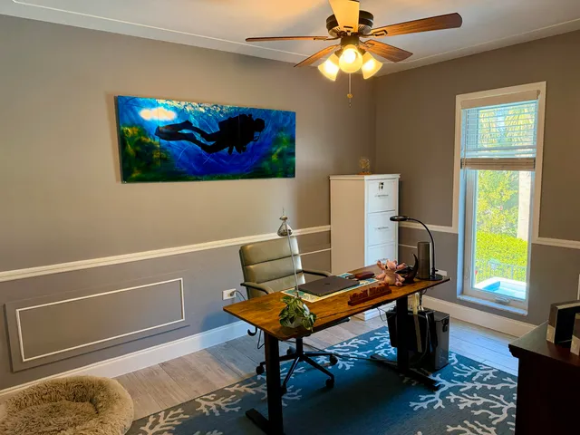 a view of a workspace with furniture and a window