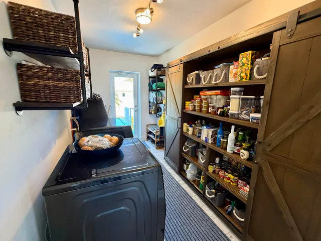 a room with lots of books and a refrigerator