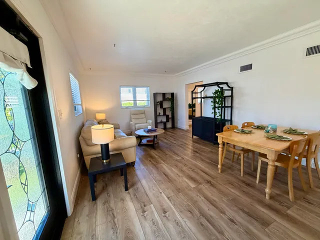 a living room with furniture dining table and wooden floor