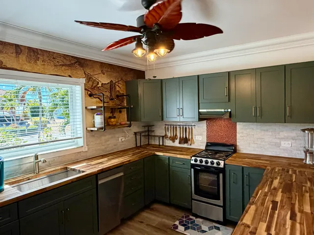 a kitchen with stainless steel appliances kitchen island granite countertop a sink and a stove