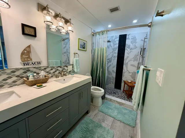 a bathroom with a sink a toilet and mirror
