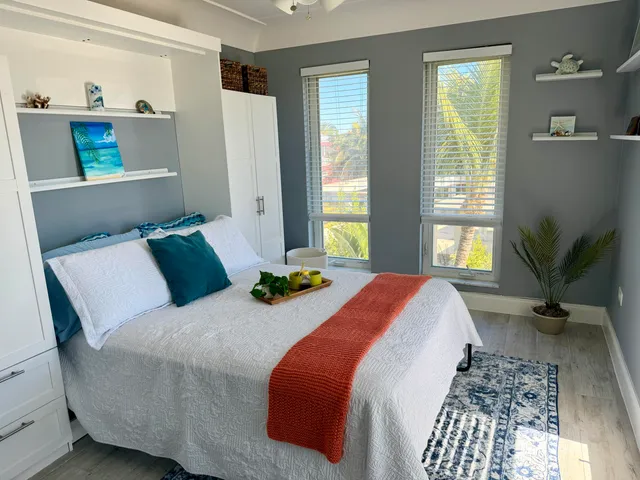 a bedroom with bed and two windows