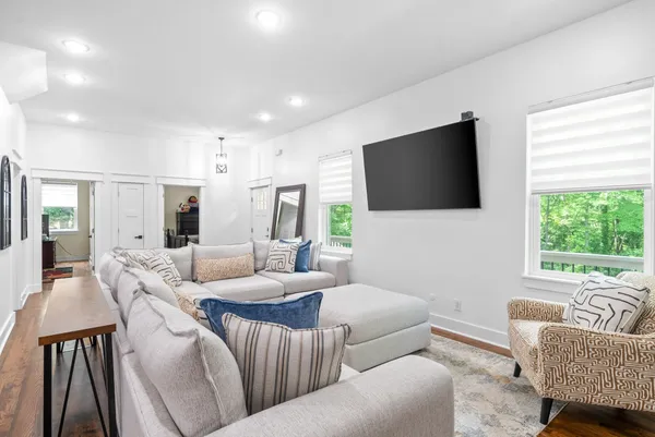 a kitchen with stainless steel appliances granite countertop a refrigerator a sink dishwasher a stove and white cabinets with wooden floor