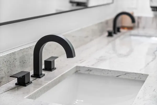 a bathroom with a granite countertop sink mirror vanity and toilet