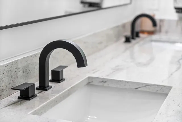 a bathroom with a granite countertop sink mirror vanity and toilet