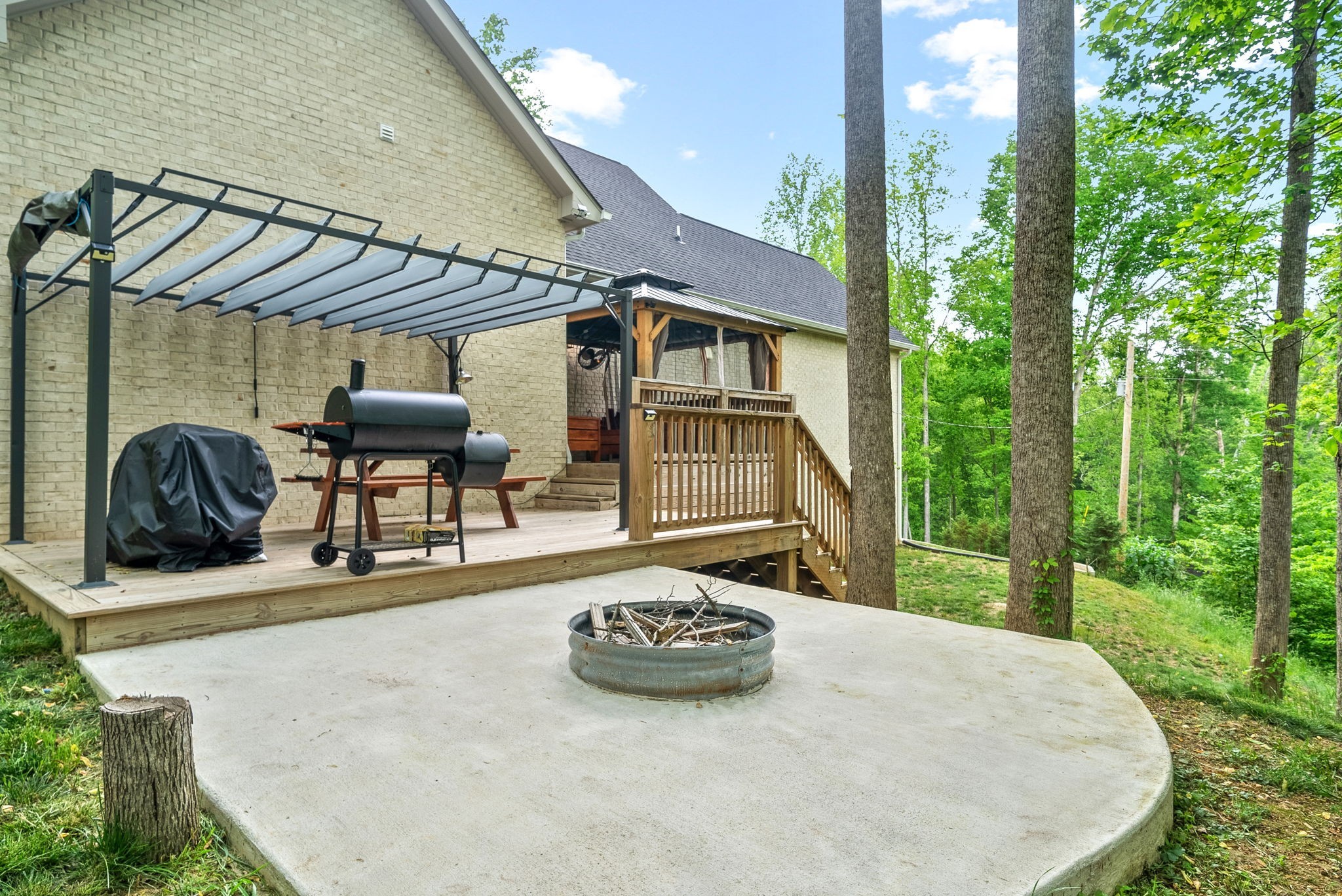 514 Doy Road White Bluff, TN 37187 - Photo 40 of 57 a view of a patio with table and chairs a barbeque with potted plants and large tree