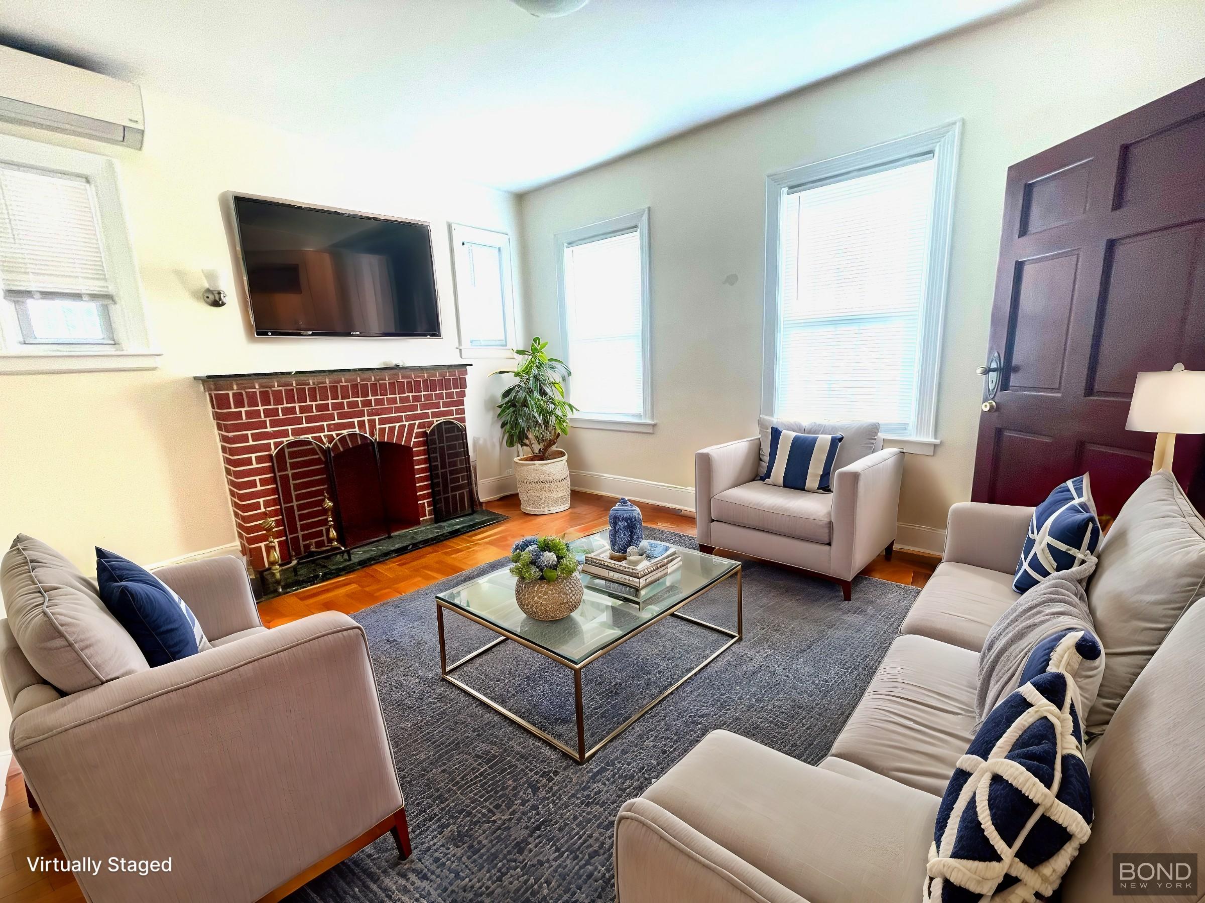 a living room with furniture a flat screen tv and a fireplace