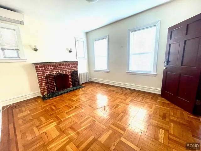 a view of an empty room with a fireplace and a window