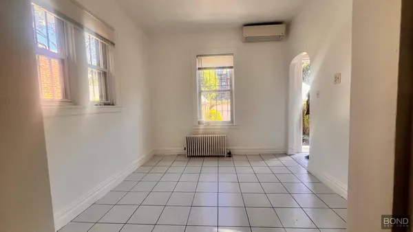 a view of an empty room with window and bathroom