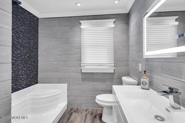 a bathroom with a sink a toilet and shower