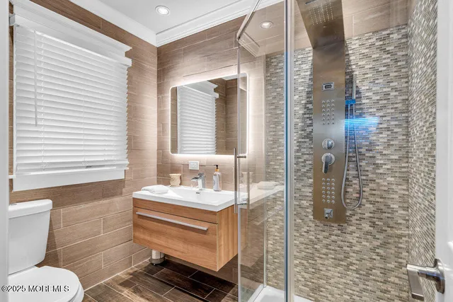 a bathroom with a sink a toilet and shower