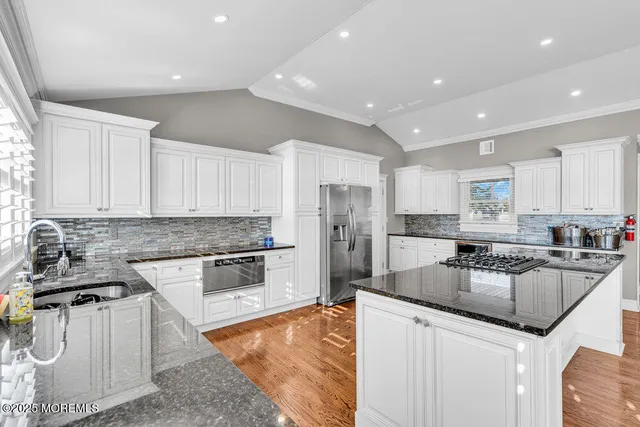 a kitchen with stainless steel appliances granite countertop a sink stove and refrigerator