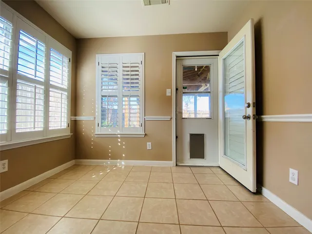 a view of an empty room with window and cabinet