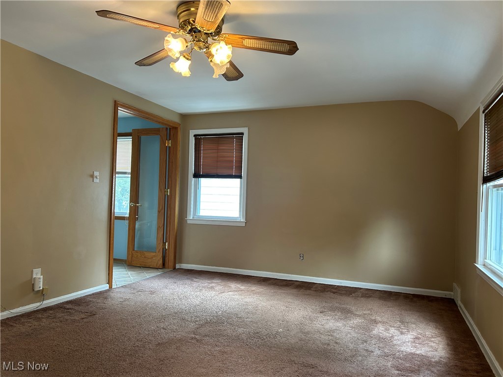 1194 Croyden Road Lyndhurst, OH 44124 - Photo 19 of 25 Empty room with light colored carpet, vaulted ceiling, and a ceiling fan