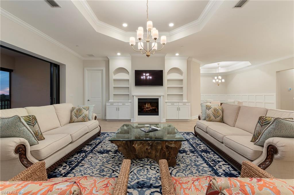15328 Lucerna Street, Unit 202 Naples, FL 34114 - Photo 3 of 32 a living room with furniture a fireplace and a chandelier