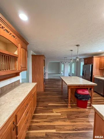 a dining hall with stainless steel appliances granite countertop a stove and a kitchen island