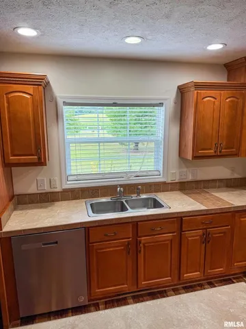 a kitchen with granite countertop a sink and cabinets