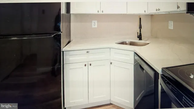 a kitchen with a refrigerator and white cabinets