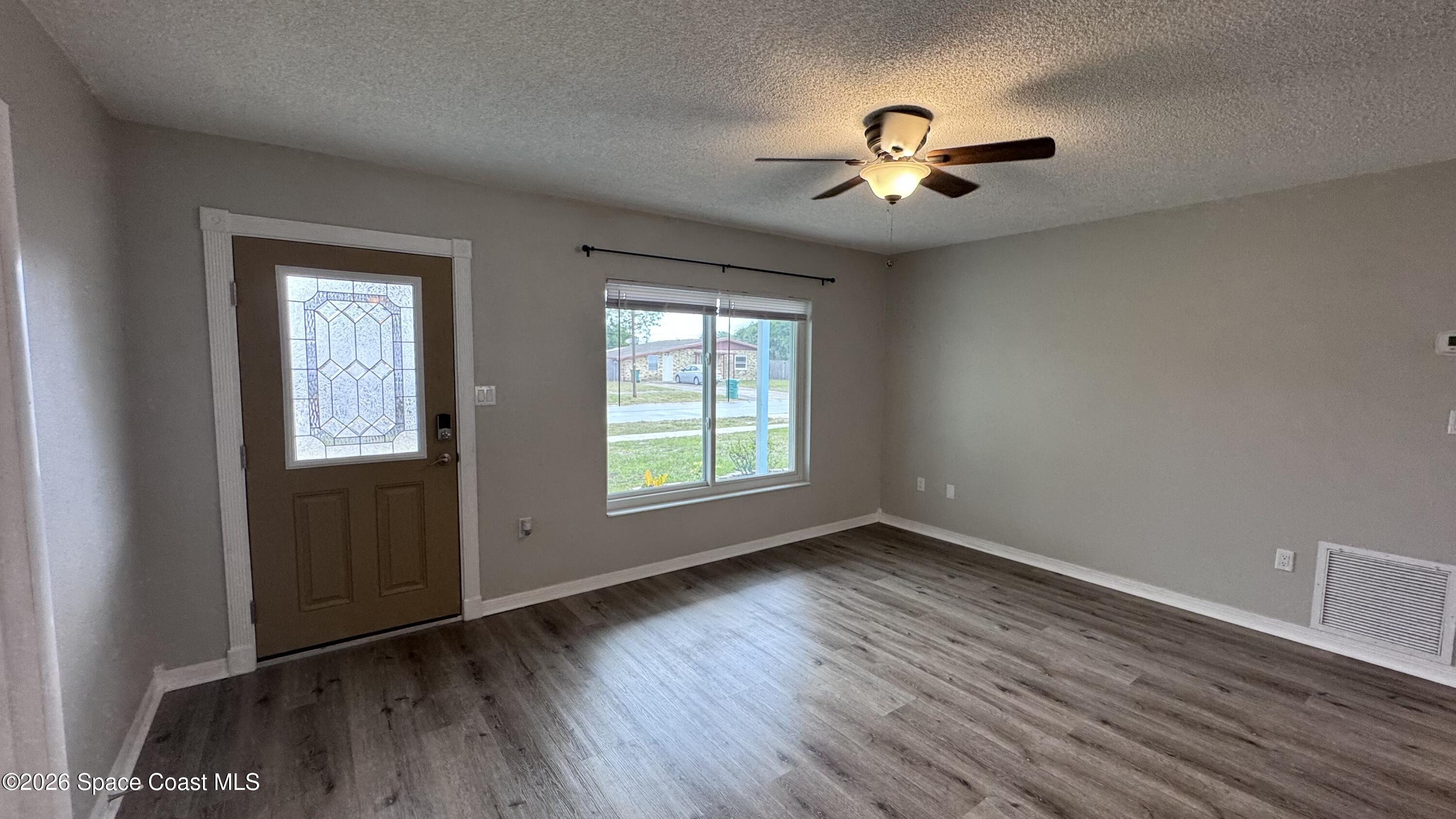 2137 Laden Road Melbourne, FL 32935 - Photo 6 of 23 a view of empty room with wooden floor and fan