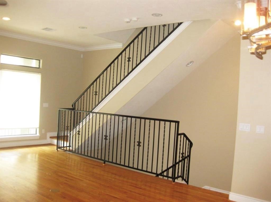 1623 Stuart Street Houston, TX 77004 - Photo 8 of 24 Another view of the living room, note the crown molding throughout the second level. The rod iron railing is a beautiful and decorative touch