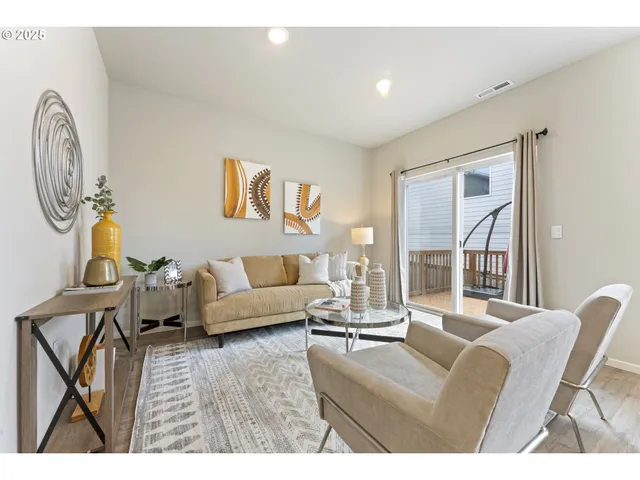 a living room with furniture a large window and potted plants