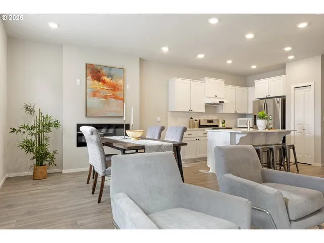 a living room with furniture and a dining table with kitchen view